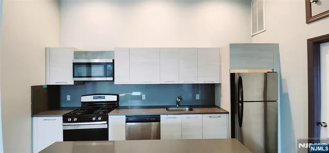 a kitchen with stainless steel appliances a refrigerator stove and microwave