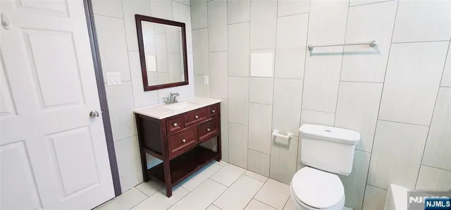 a bathroom with a toilet sink vanity and mirror