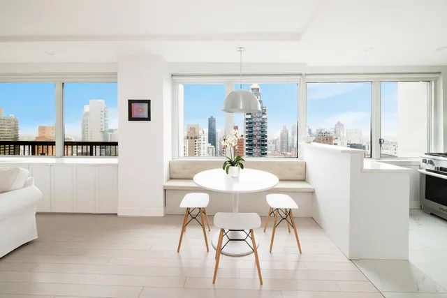 a dining room with furniture and a large window