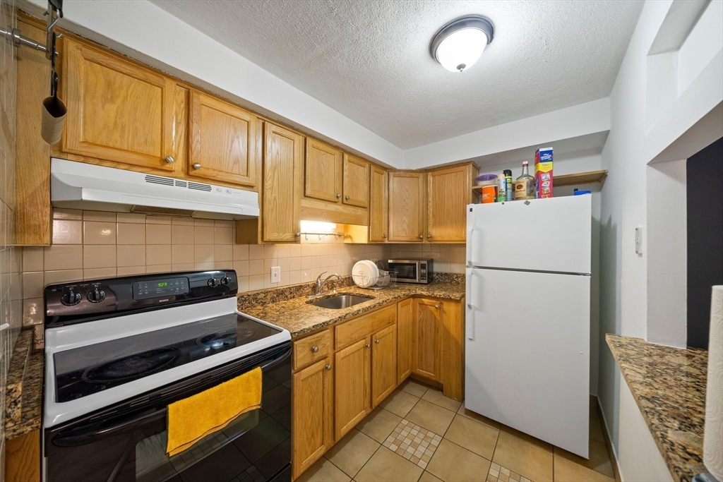 915 Edgell Road, Unit 77 Framingham, MA 01701 - Photo 7 of 15 a kitchen with a refrigerator and a stove