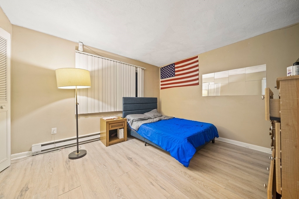 915 Edgell Road, Unit 77 Framingham, MA 01701 - Photo 8 of 15 a bedroom with a bed and a lamp on the table