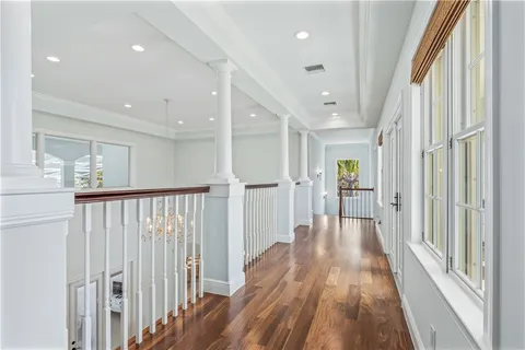 a view of a hallway with wooden floor and staircase