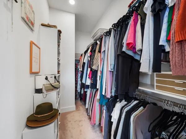 a view of walk in closet with clothes and shoes