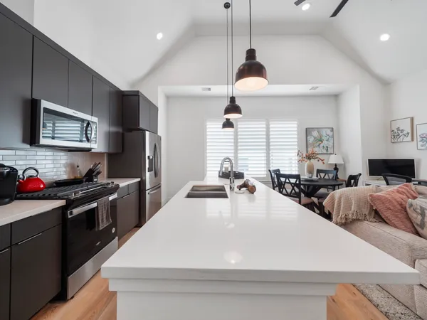 a large kitchen with kitchen island a counter space a sink a window and stainless steel appliances