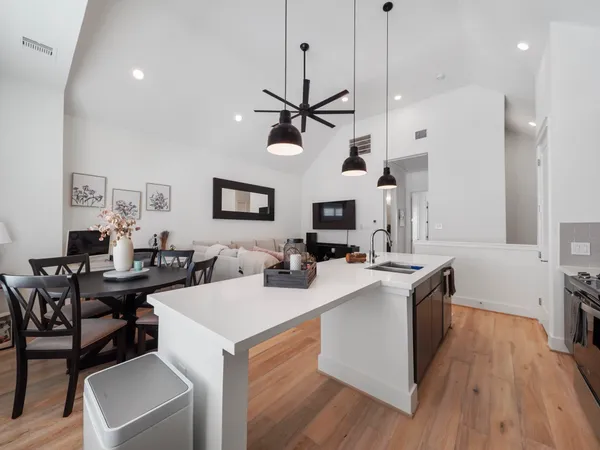 a kitchen with a stove a sink a dining table and chairs