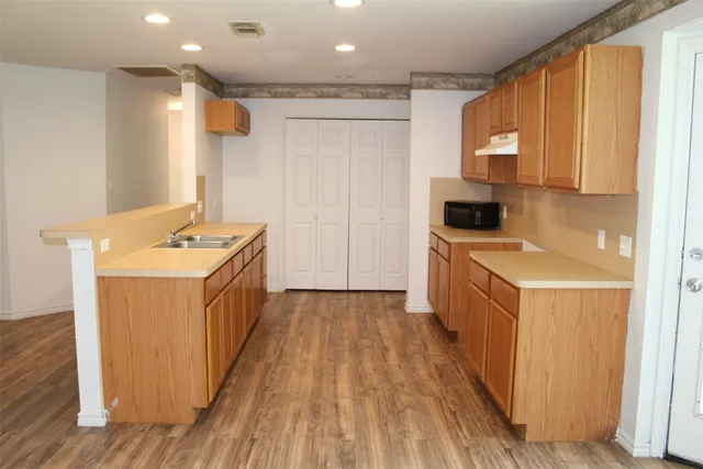 a kitchen with stainless steel appliances granite countertop a sink and wooden cabinets