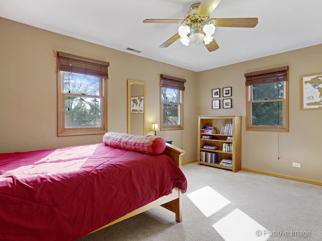 318 East Elm Street Wheaton, IL 60189 - Photo 11 of 17 a bedroom with a bed and dresser with mirror
