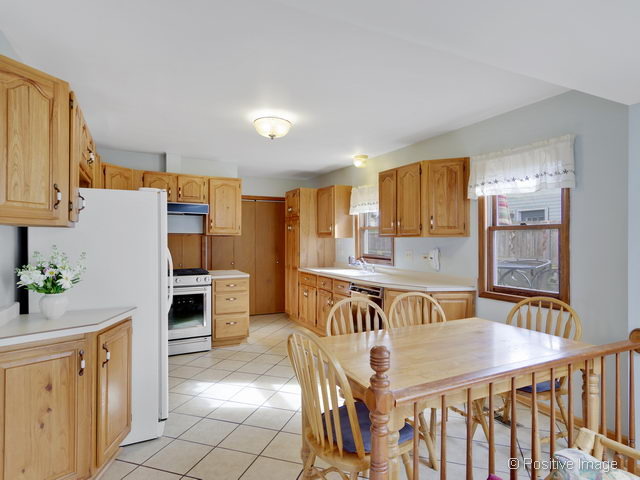 318 East Elm Street Wheaton, IL 60189 - Photo 6 of 17 a kitchen with stainless steel appliances granite countertop a sink a stove a dining table and chairs with wooden floor