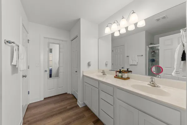 a bathroom with double vanity sinks a vanity a lamp and a mirror