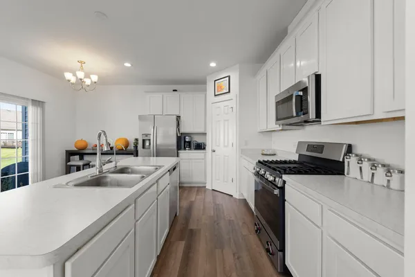 a kitchen with stainless steel appliances granite countertop a sink stove microwave and cabinets