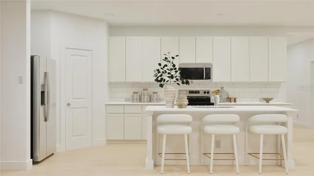 a kitchen with granite countertop white cabinets and stainless steel appliances