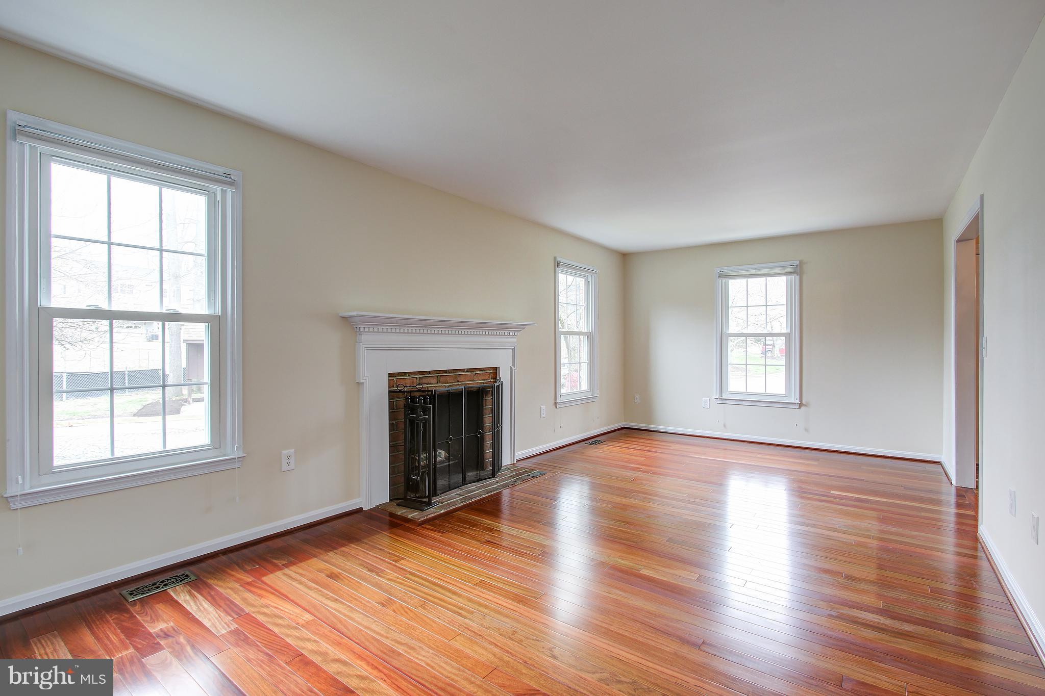 1030 Windrush Lane, Unit 31 Sandy Spring, MD 20860 - Photo 6 of 30 an empty room with wooden floor windows and fireplace