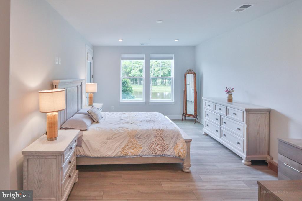 190 Harrier Way, Unit 11 Chester, MD 21619 - Photo 14 of 32 a bedroom with a bed and wooden floor