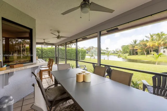 a front view of a house with a yard and palm trees
