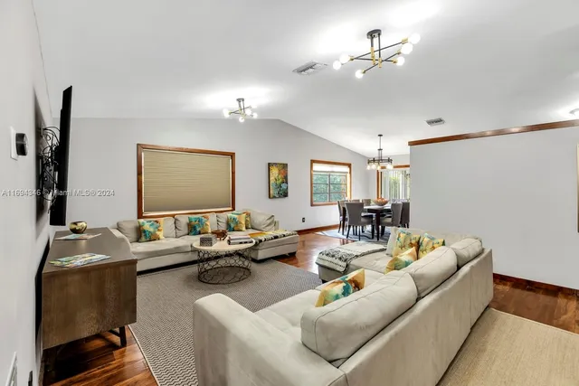 a living room with furniture ceiling fan and a wooden floor