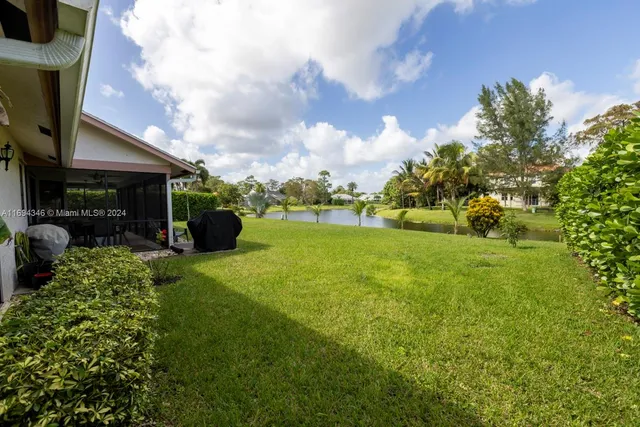 an aerial view of residential houses with outdoor space and trees
