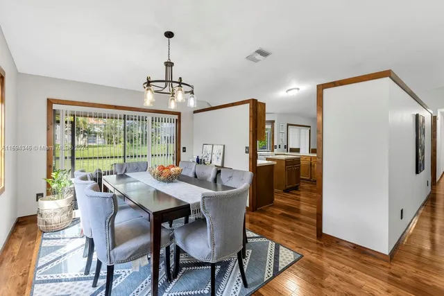 a kitchen with stainless steel appliances granite countertop a refrigerator a stove and a sink with wooden floor