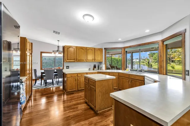 a large kitchen with kitchen island granite countertop a large window cabinets and stainless steel appliances