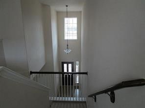 a view of a big room with wooden floor a ceiling fan and windows