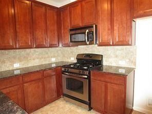 a kitchen with kitchen island granite countertop wooden cabinets and a stove
