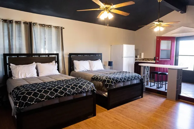 a bedroom with a bed lamps and wooden floor