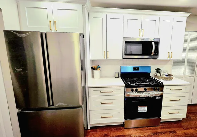 a kitchen with stainless steel appliances white cabinets and a refrigerator