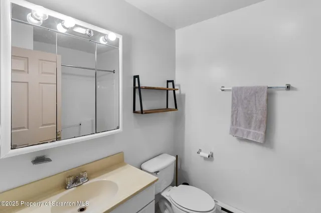 a bathroom with a sink and mirror with toilet