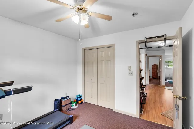 a view of a livingroom with a chandelier fan and wooden floor