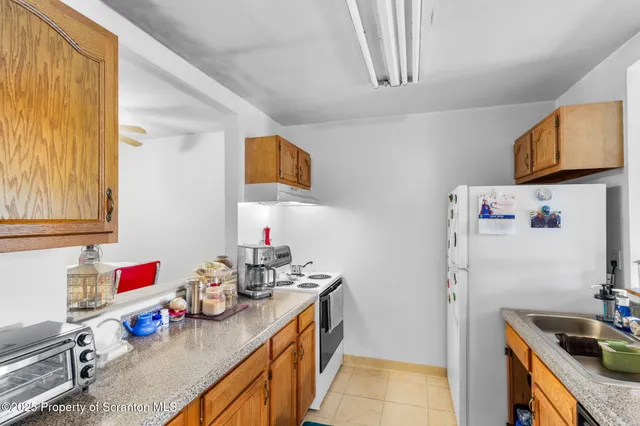 a kitchen with granite countertop a sink stove and cabinets