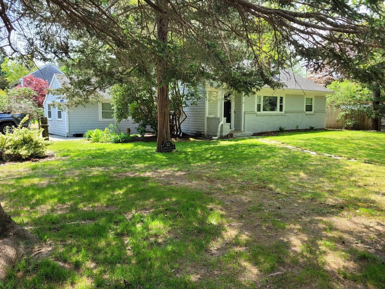 52 Ploughed Neck Road East Sandwich, MA 02537 - Photo 2 of 20 a backyard of a house with plants and large tree