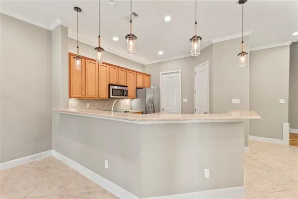 a kitchen with stainless steel appliances granite countertop a sink a stove a counter space and a window