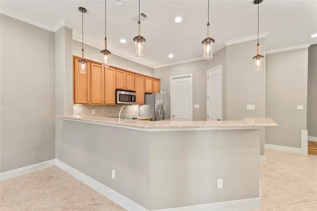 a kitchen with stainless steel appliances granite countertop a sink a stove a counter space and a window