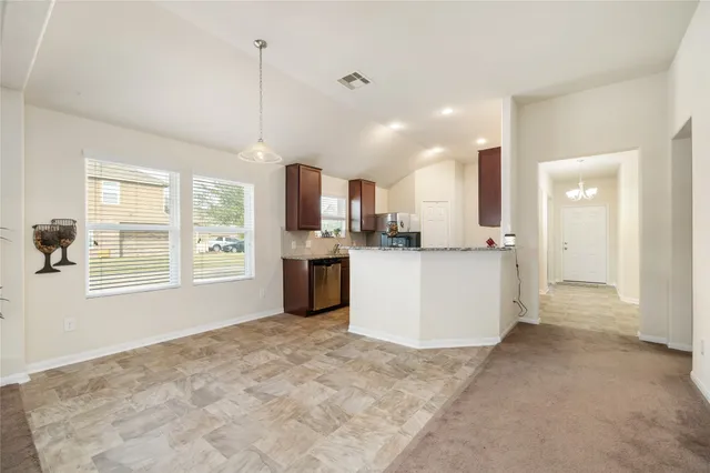 a view of kitchen with stainless steel appliances granite countertop cabinets and window