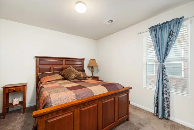 a bed sitting in a bedroom next to a window