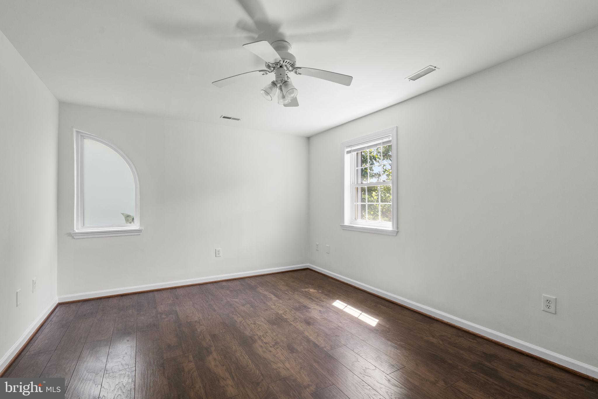 24000 Clarksburg Road Clarksburg, MD 20871 - Photo 38 of 60 an empty room with wooden floor chandelier fan and windows