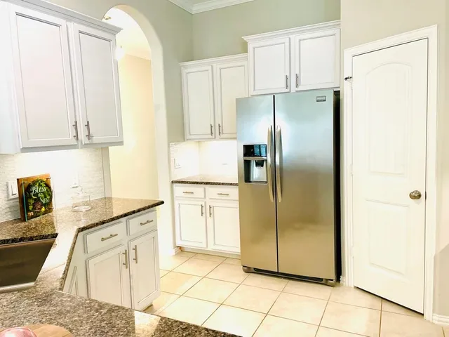 a kitchen with stainless steel appliances granite countertop a refrigerator and a stove