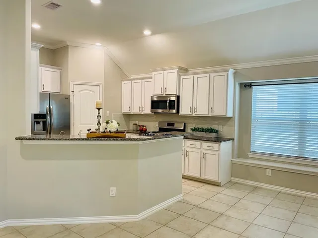 a kitchen with stainless steel appliances granite countertop a refrigerator sink and stove