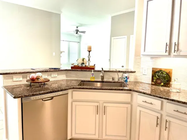 a kitchen with stainless steel appliances granite countertop a sink a stove and cabinets