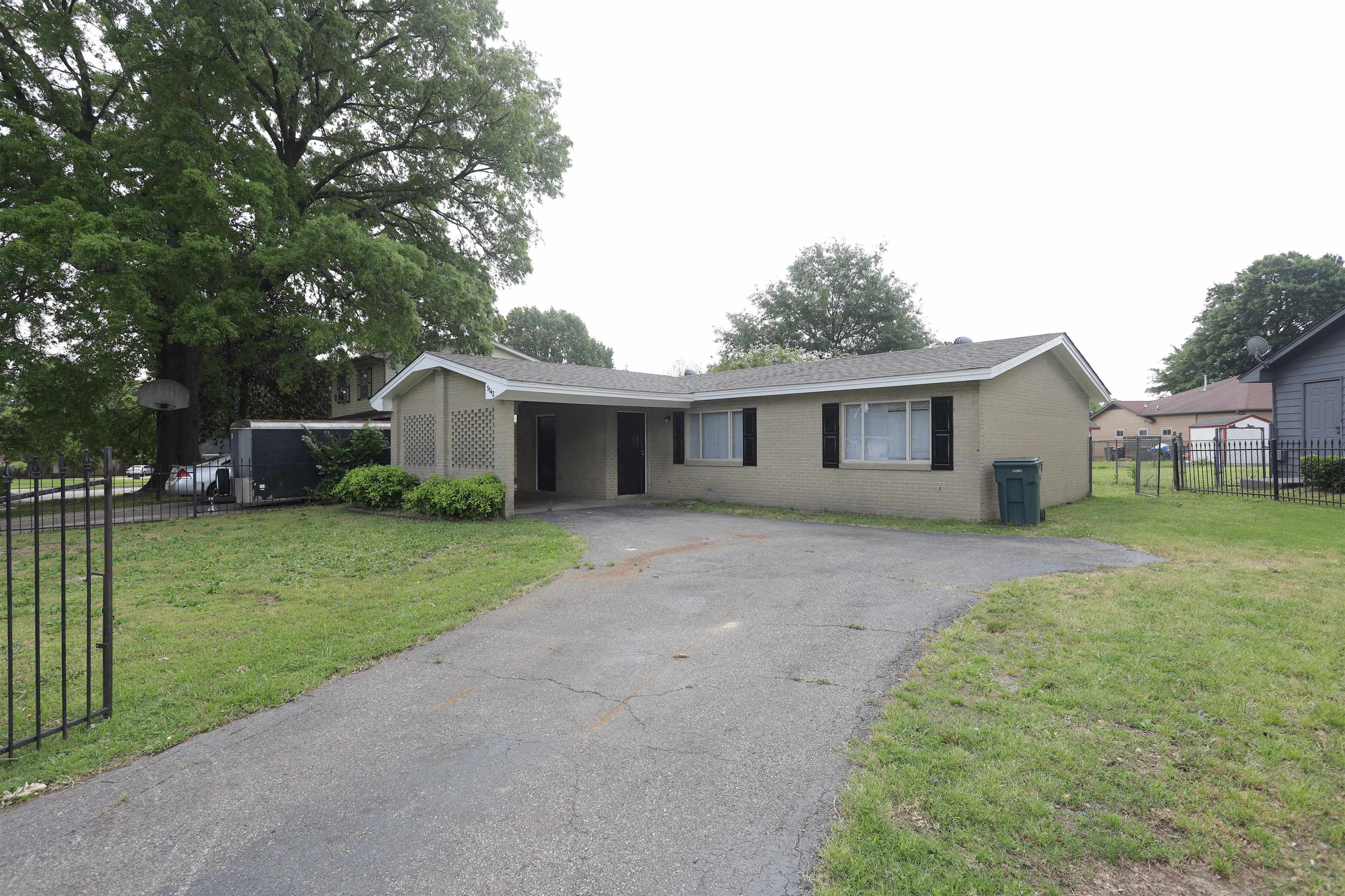 a front view of house with a garden and trees