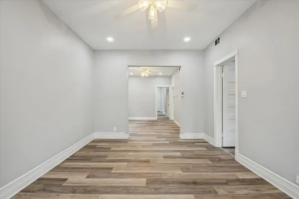 a view of a hallway with wooden floor and a chandelier