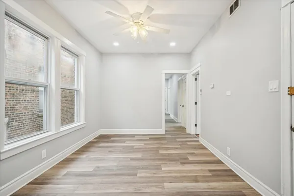 a view of an empty room with a window and a ceiling fan