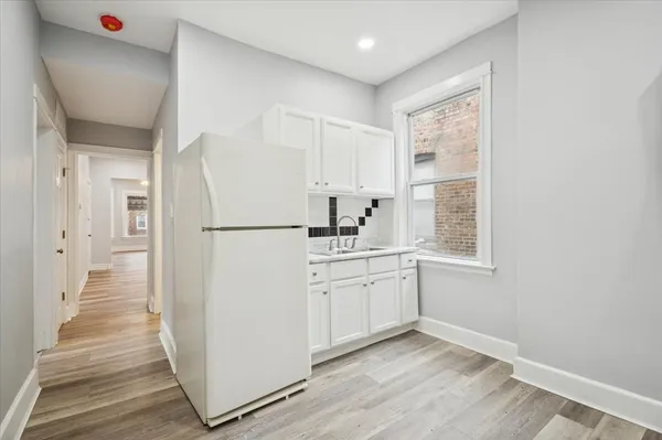 a kitchen with sink refrigerator and cabinets