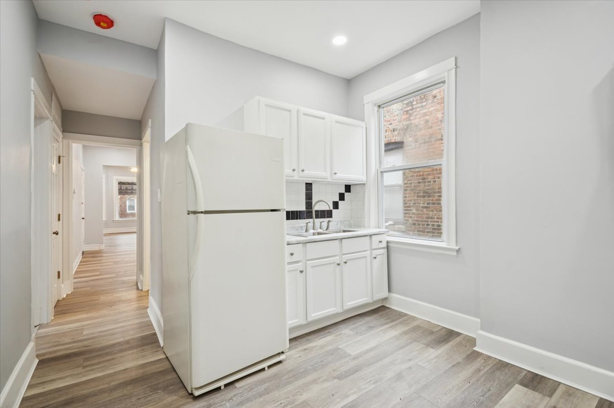 6338 South Ada Street, Unit 2 Chicago, IL 60636 - Photo 6 of 12 a kitchen with sink refrigerator and cabinets