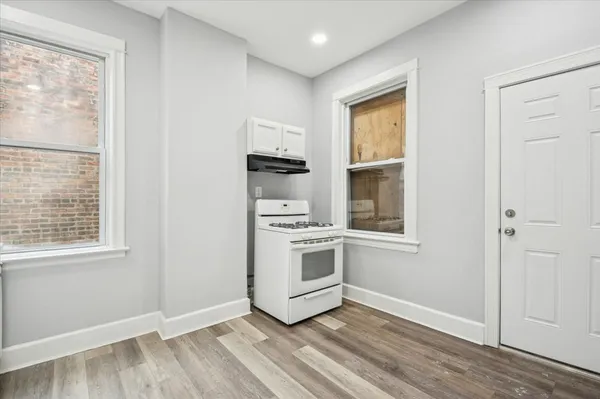 a view of a kitchen with wooden floor and windows