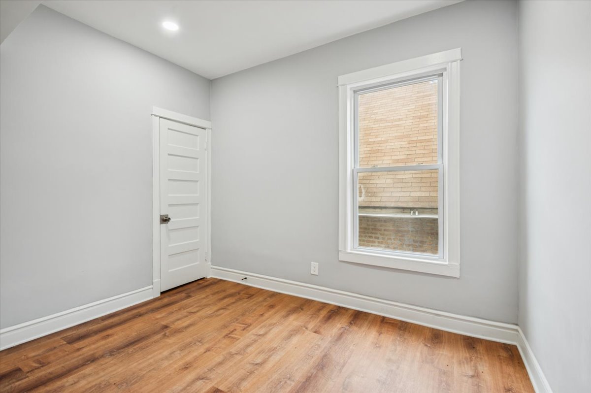 6338 South Ada Street, Unit 2 Chicago, IL 60636 - Photo 10 of 12 an empty room with wooden floor and windows