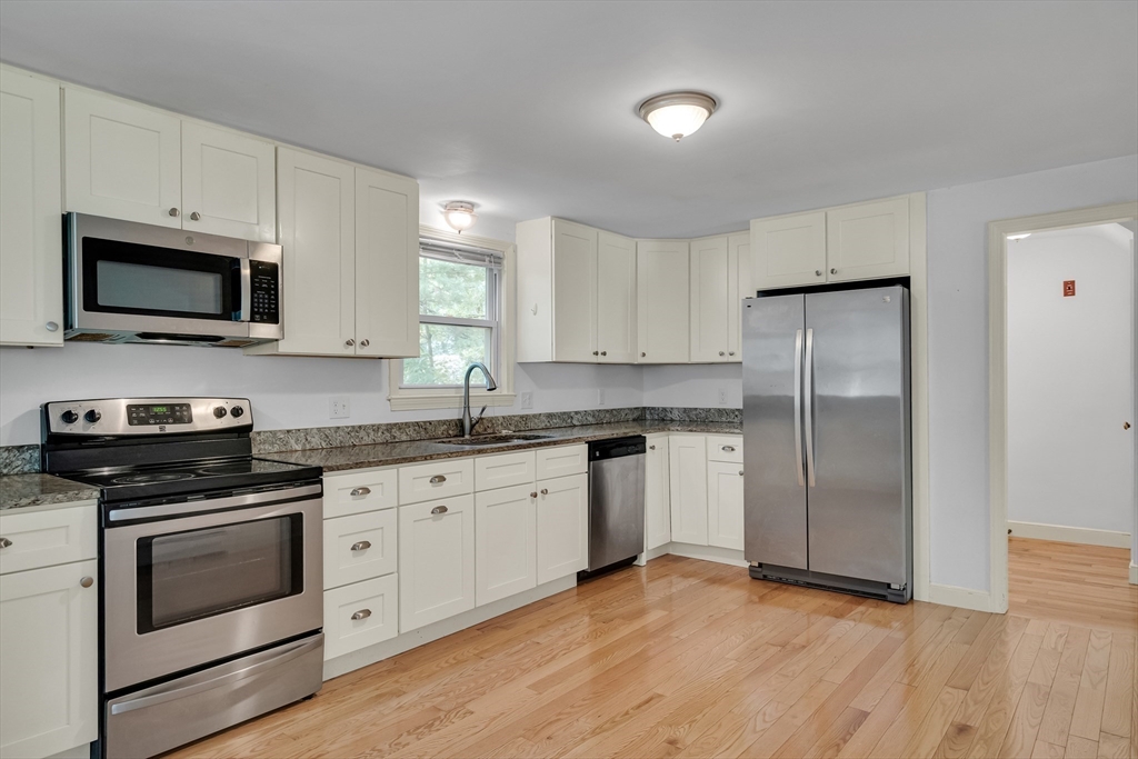 32 Dewey Road Lexington, MA 02420 - Photo 13 of 32 a kitchen with granite countertop cabinets stainless steel appliances and wooden floor
