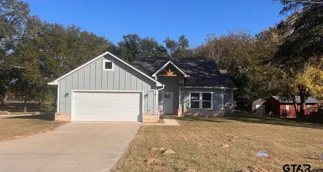 a view of a house with a yard and garage