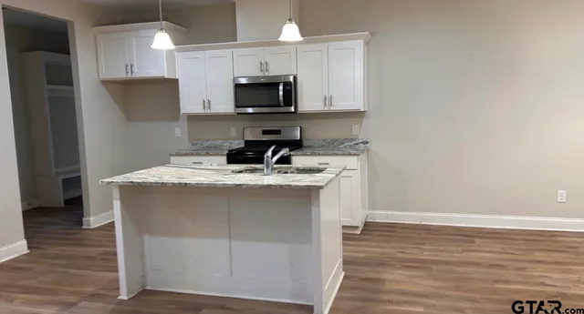 a kitchen with stainless steel appliances a sink stove and microwave
