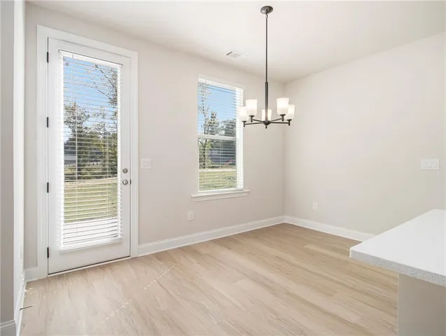 a view of a room with wooden floor exposed radiator and windows