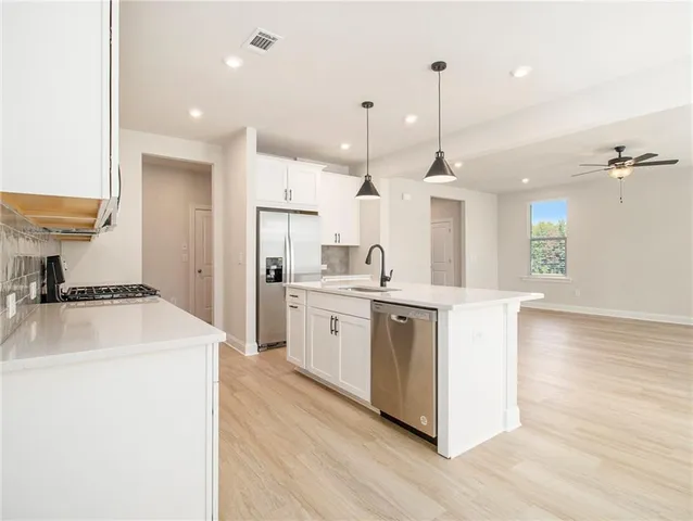 a kitchen with white cabinets and sink